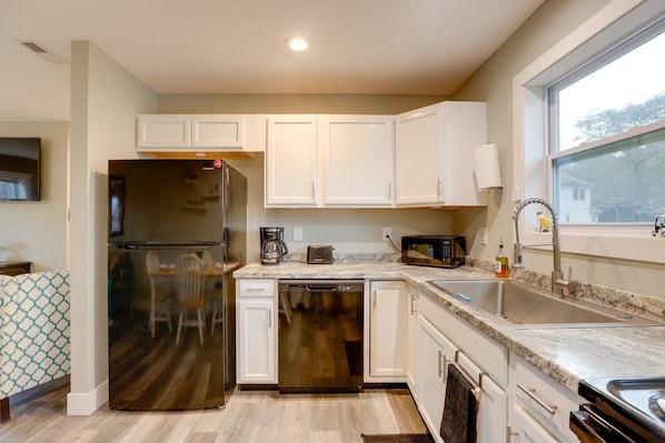 A modern kitchen with white cabinets, a stainless steel refrigerator, a dishwasher, a coffee maker, and a microwave. - Luxury Golf Villa w/ Hot Tub Stunning Golf Course Views Near OBX Beaches (Kitty Hawk)