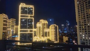 Une vue nocturne d’une ville, avec des gratte-ciel illuminés.