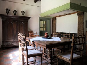A traditional dining room with a wooden table and chairs, a cabinet with decorative items, and a green painted ceiling. - Traumhaftes, Antikes Ferienhaus in Alleinlage Inmitten der Natur (Hamminkeln)