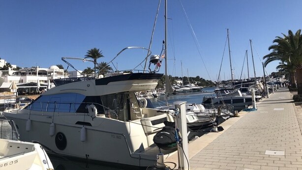 A marina with several yachts docked, a paved walkway, and palm trees in the background. - Villa with sea view and pool in Cala D' Or (Santanyí)