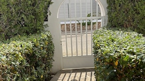 A gated entrance with a stone pathway leading to a white building. - Villa with sea view and pool in Cala D' Or (Santanyí)