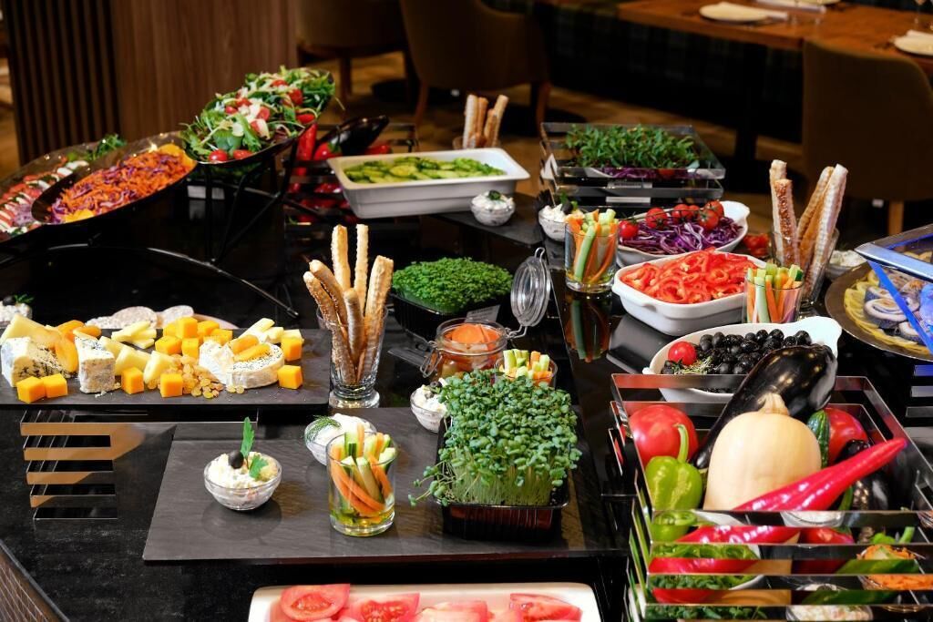 A buffet table with various food items and condiments.