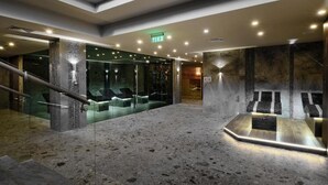 A modern lobby with a glass wall, a reception desk, and a stone floor. - Luxury Apartments St Ivan Rilski SPA 4 (Bansko)