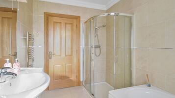A bathroom with a shower, a sink, and a toilet.
