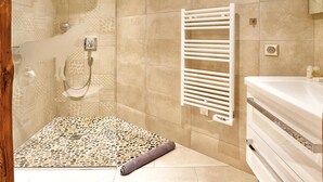 Une salle de bain moderne avec une douche, un porte-serviettes blanc et un meuble-lavabo avec un miroir.