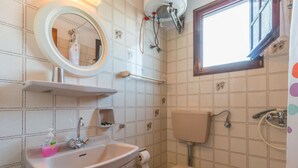 A bathroom with a sink, toilet, and shower. There is a mirror above the sink and a window above the toilet. - Villa Zina Studio 1 (Zagora-Mouresi)