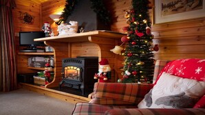 Un salón acogedor con chimenea, un árbol de Navidad y decoraciones festivas.