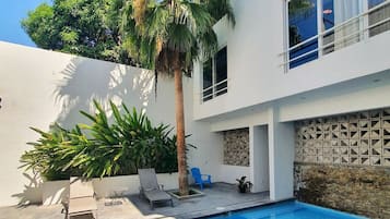 Una piscina al aire libre, sillones reclinables de piscina