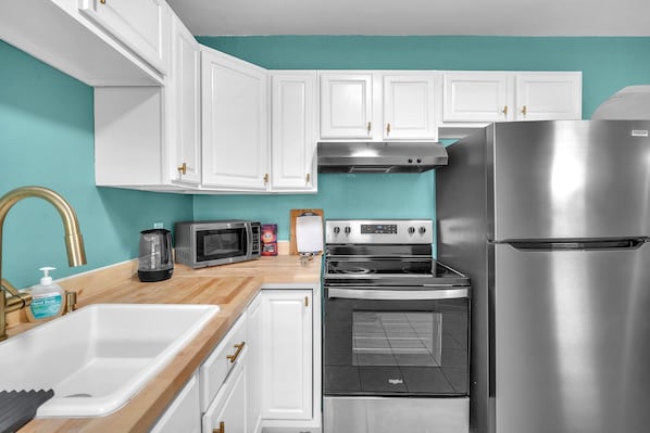 Enjoy cooking in this well-equipped kitchen with a double sink, microwave, coffee maker, and refrigerator.