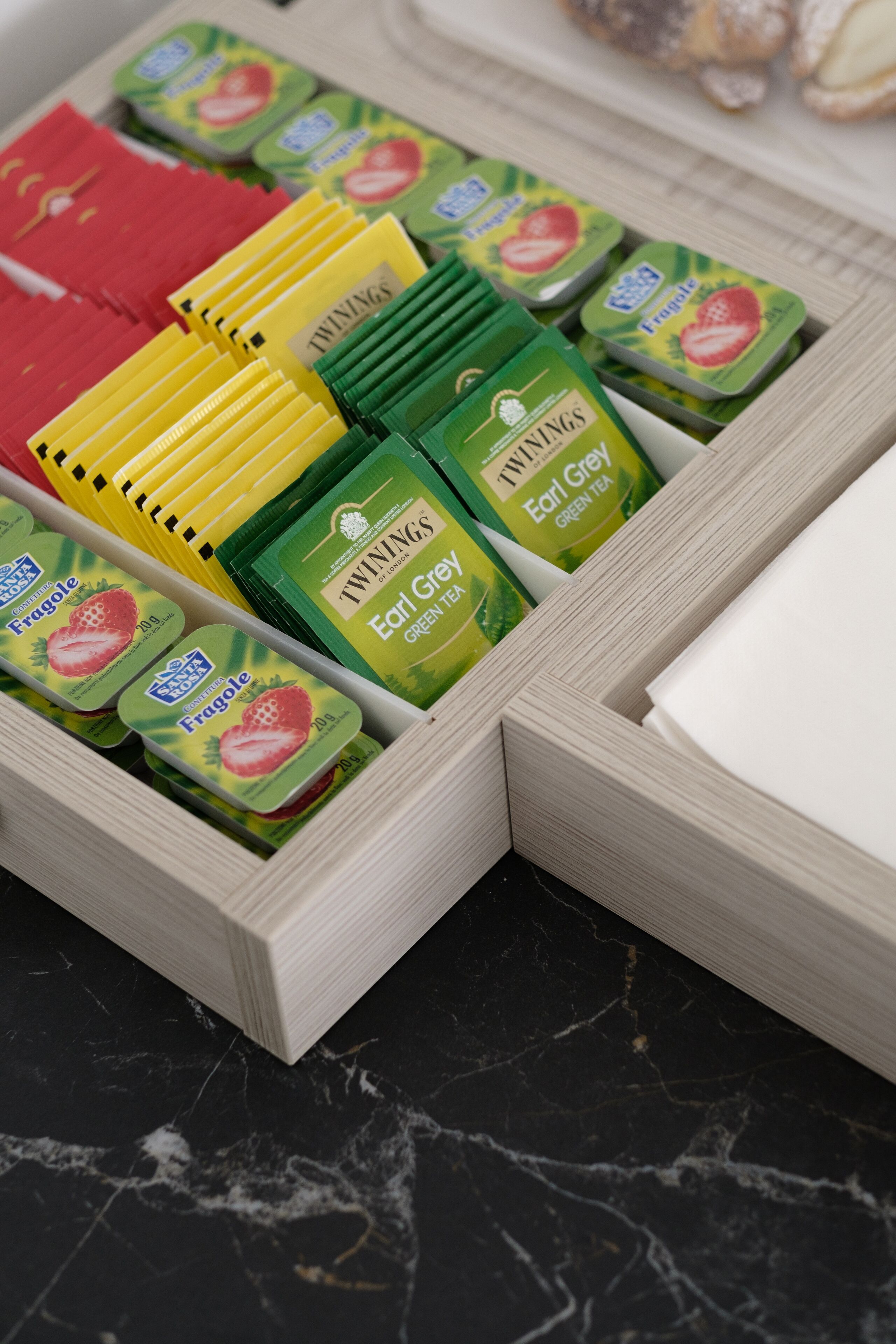 A drawer containing various tea packets, including Earl Grey and Fragole brands.