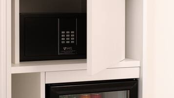A compact refrigerator with a freezer compartment, containing various beverages and bottles.