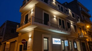 A multi-story building with balconies, illuminated signs, and a no parking sign. - Domea Superior Rooms (Reggio Calabria)