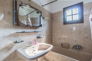 Une salle de bain avec un lavabo, un miroir et une douche.
