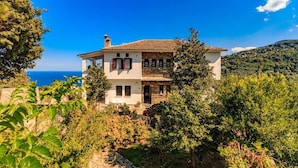 A two-story house with a stone facade, a tiled roof, and a view of the sea. - Apartment Zina Pelion (Zagora-Mouresi)