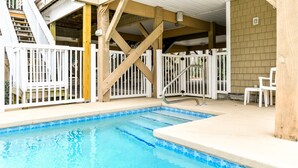 Une piscine dotée d’une terrasse en bois et de rampes blanches.