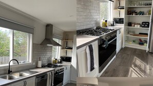 Une cuisine moderne avec des armoires blanches, une cuisinière en acier inoxydable et un four encastré.