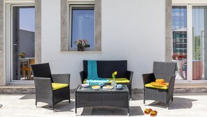 An outdoor seating area with wicker furniture, a table with dishes, and a vase with flowers. - Accogliente appartamento con piscina privata.
TROPICAL LOFT (Salemi)