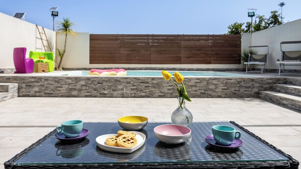 A glass table with bowls and a vase with flowers, a pool in the background, and outdoor seating. - Accogliente appartamento con piscina privata.
TROPICAL LOFT (Salemi)