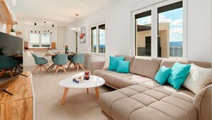 A modern living room with a beige sofa, teal chairs, and a white coffee table. - Modern Villa AdriaStar with a swimming pool (Dugi Rat)