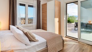 A bedroom with a bed, a window with curtains, a sliding glass door leading to an outdoor area, and a view of the outdoors. - Modern Villa AdriaStar with a swimming pool (Dugi Rat)