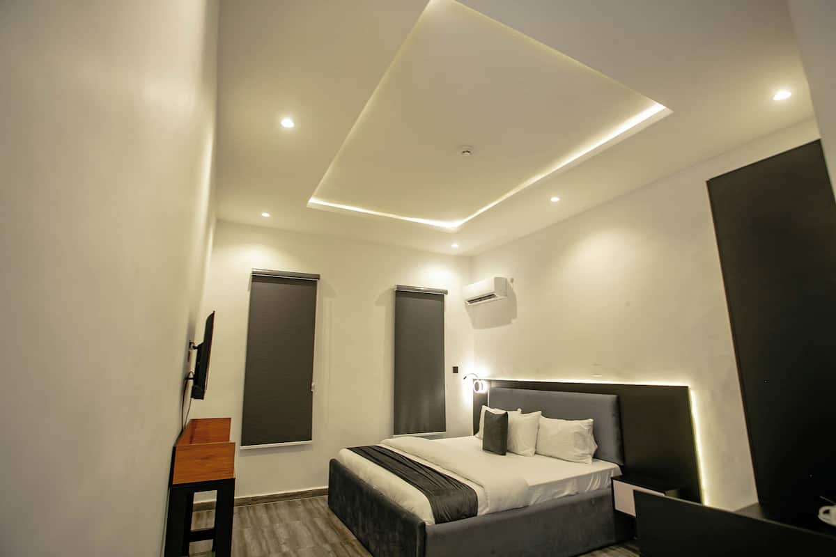 A modern bedroom with a bed, bedside tables, and a ceiling light fixture.