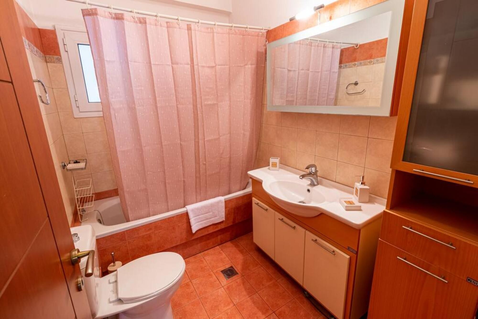 A bathroom with a toilet, sink, and shower.
