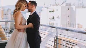A couple embracing on a balcony with a cityscape view. - Armonia Rentals Volos Flat (Volos)