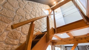 A wooden staircase with a stone wall background. - Gîte Classé 3 Avec Sauna Chez Chanchan 4/ 6 Pers (Dambach-la-ville)