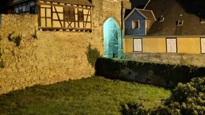 A stone building with a tower, a thatched-roof house, and a blue-lit entrance. - Gîte Classé 3 Avec Sauna Chez Chanchan 4/ 6 Pers (Dambach-la-ville)