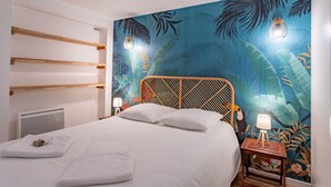A neatly made bed with white linens, a wooden headboard, and a small bedside table with a lamp.