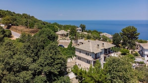 A coastal village with traditional stone houses, a narrow road, and a view of the sea.
