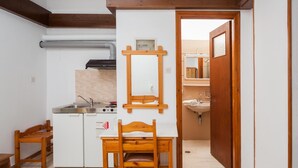 A compact kitchen with a built-in stove, a sink, and wooden furniture.