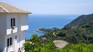 A white building with air conditioning units, overlooking a coastal landscape with a clear view of the sea and a hilly terrain. - Paradeisos Double Room With Sea View 4 (Zagora-Mouresi)