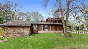 A stone and wood house with a stone foundation, a sloped roof, and a covered porch. - Timber Ridge-An Artist Retreat Infused w/Character |Perched on a Hill Overlooking Geneva Lake & Town (Lake Geneva)