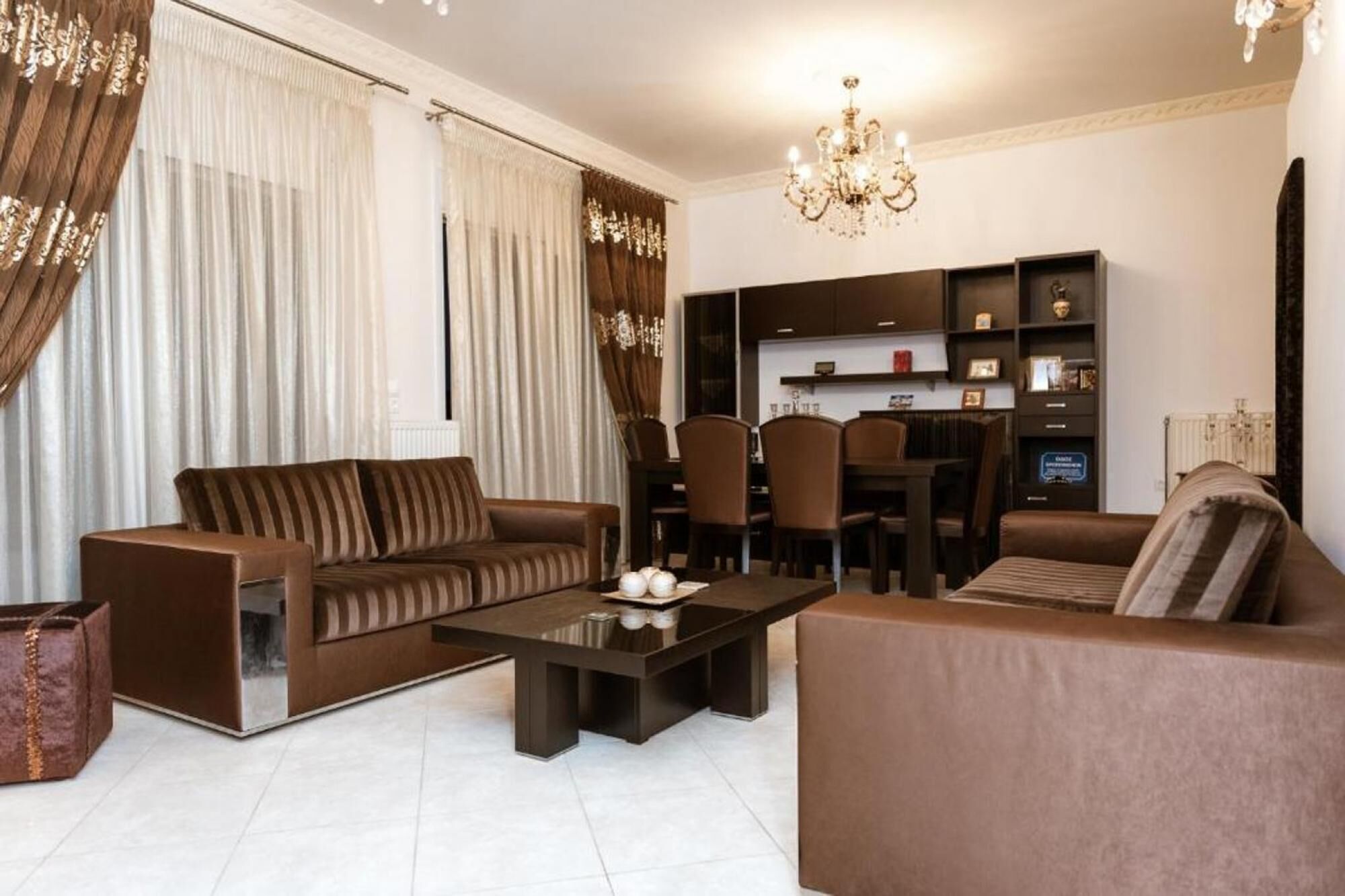 Un salon moderne comprenant un canapé, une table basse et un coin repas avec des chaises et une table.