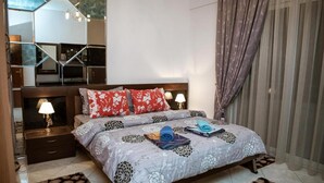 A bedroom with a bed, nightstands, and a mirror.