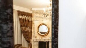 A living room with a sofa, a coffee table, a fireplace, and a mirror.