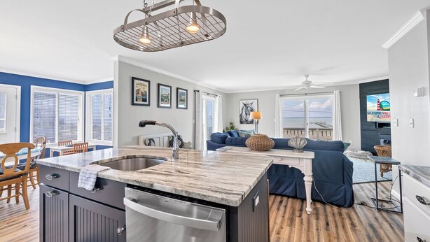 A modern kitchen with a central island, stainless steel appliances, and a unique ceiling light fixture.