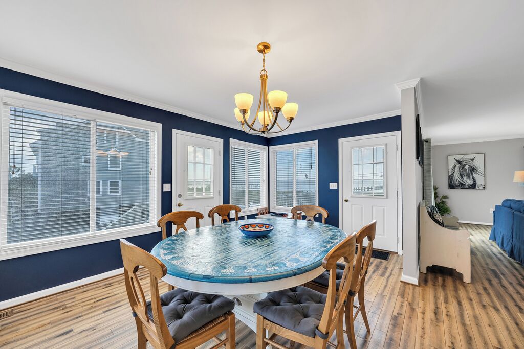 A dining room with a round table, chairs, and a chandelier.