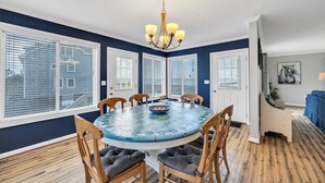 A dining room with a round table, chairs, and a chandelier.