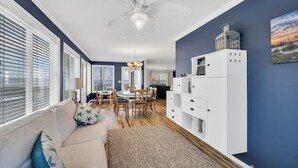 A modern living room with a sofa, dining table, and white cabinetry.
