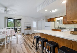 Enjoy cooking in this well-equipped kitchen with a microwave, wooden cabinets, and a large window.