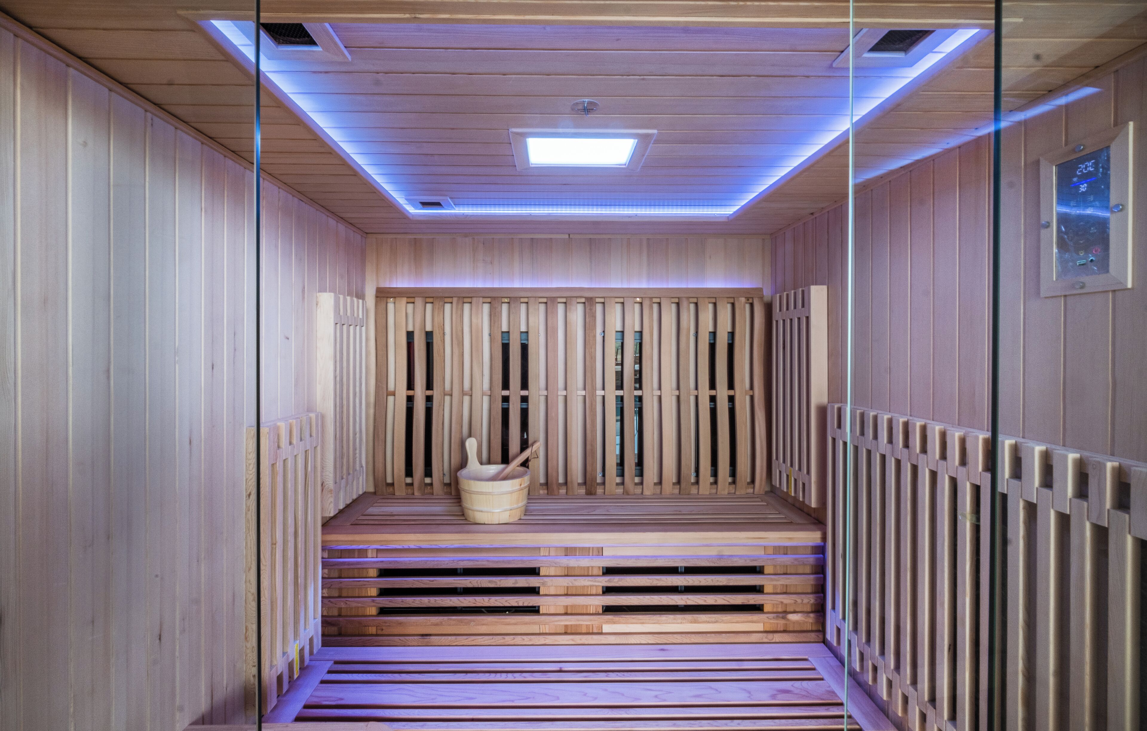 A sauna with wooden benches and a central heating element.