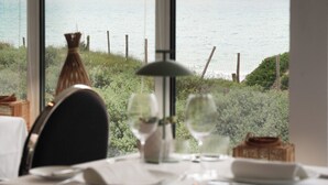 A dining table set for two with a view of the sea through large windows. - Le Grand Large  (Dolus-d'Oleron)
