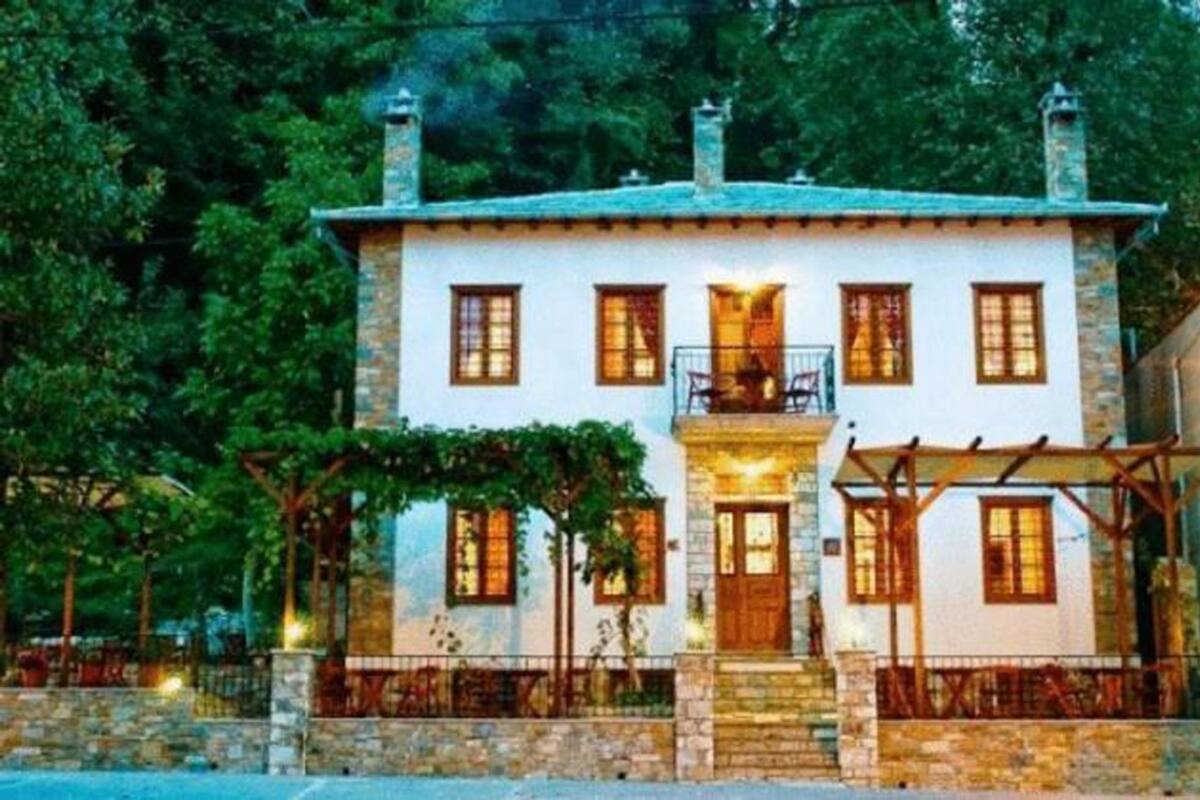 Un edificio de piedra de dos pisos con un balcón y un porche cubierto.