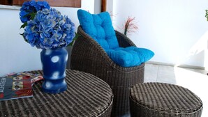 Wicker furniture with blue cushions, a blue vase with flowers, and a magazine on a table. - Paradeisos Double Room With Balcony 2 (Zagora-Mouresi)