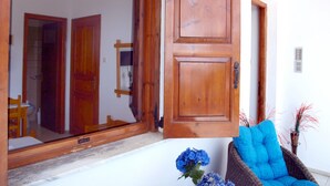 A wooden door with a mirror and a wicker chair with blue cushions. - Paradeisos Double Room With Balcony 2 (Zagora-Mouresi)