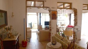 A living room with a sofa, a small table, a TV, and a fireplace.