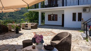 A patio area with outdoor furniture, a decorative vase, and a view of a white building with a balcony. - Paradeisos Double Room 6 (Zagora-Mouresi)