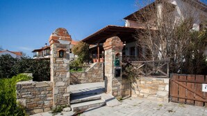 A stone entrance with steps leading to a covered porch, surrounded by a wooden fence and a gate. - Harmony Platanidia Pelion (Volos)